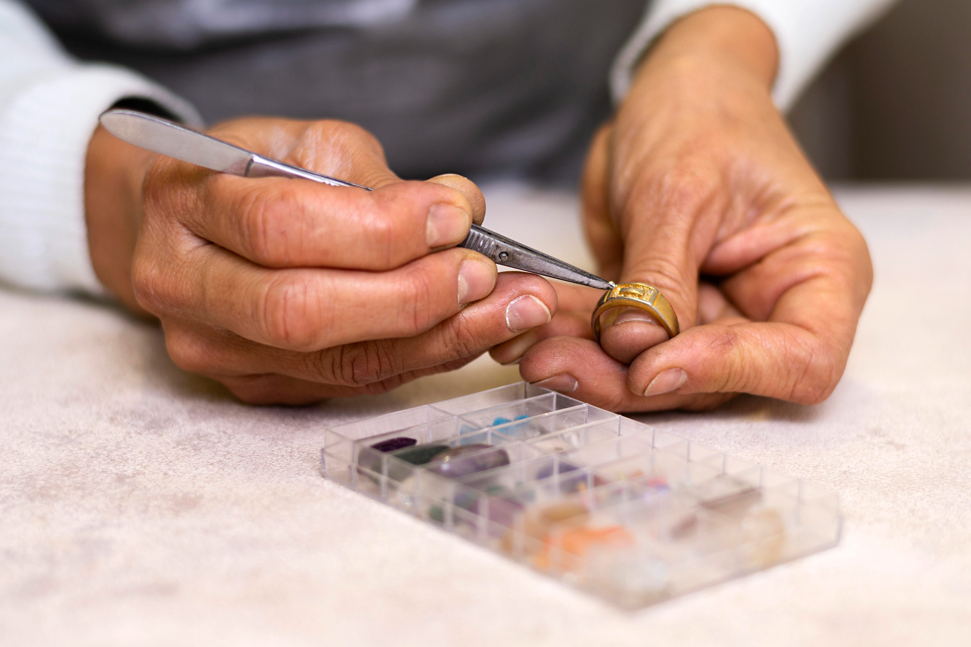 Jeweler setting gemstones into gold ring