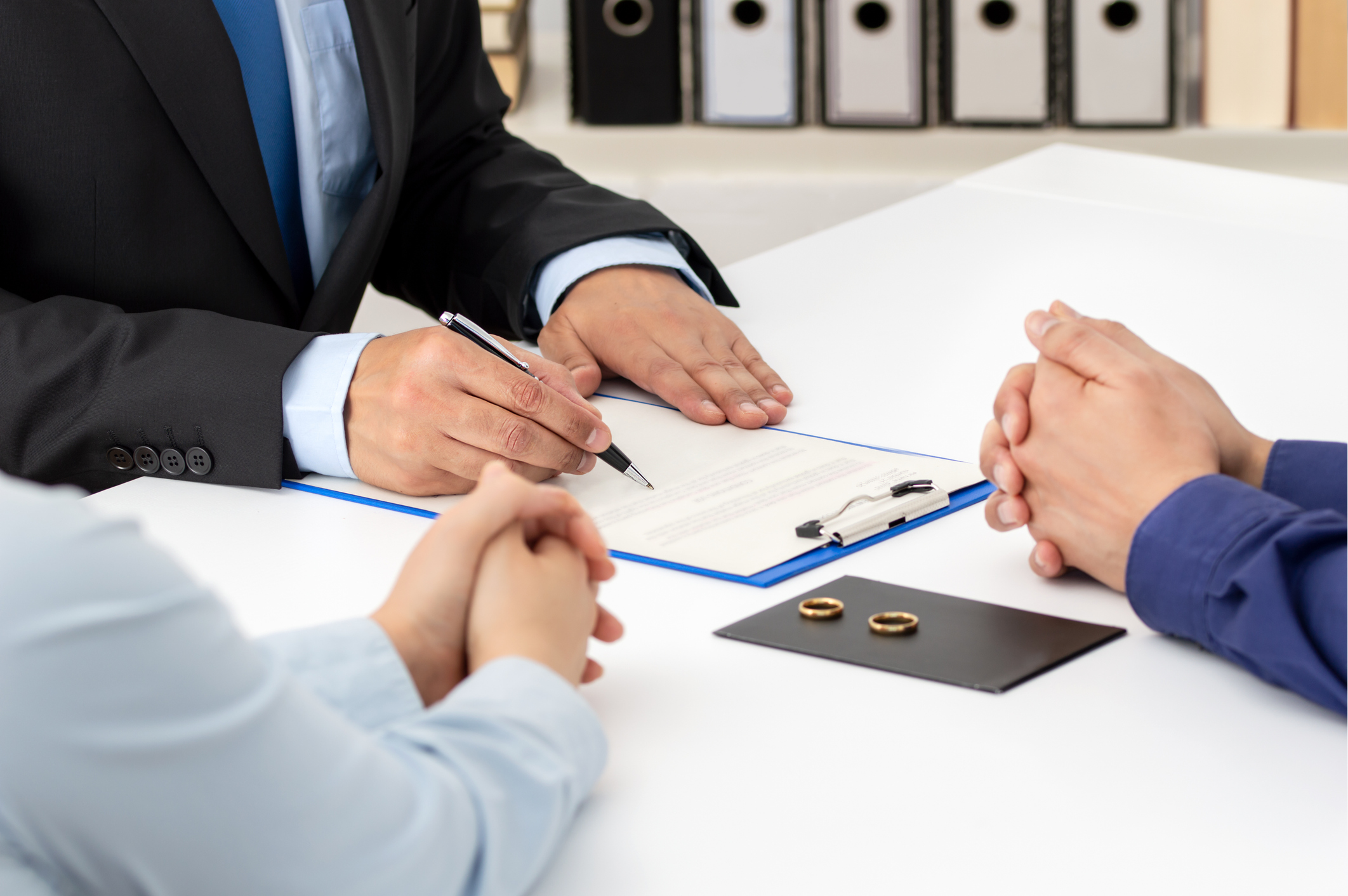 Couple signing marriage documents with wedding rings