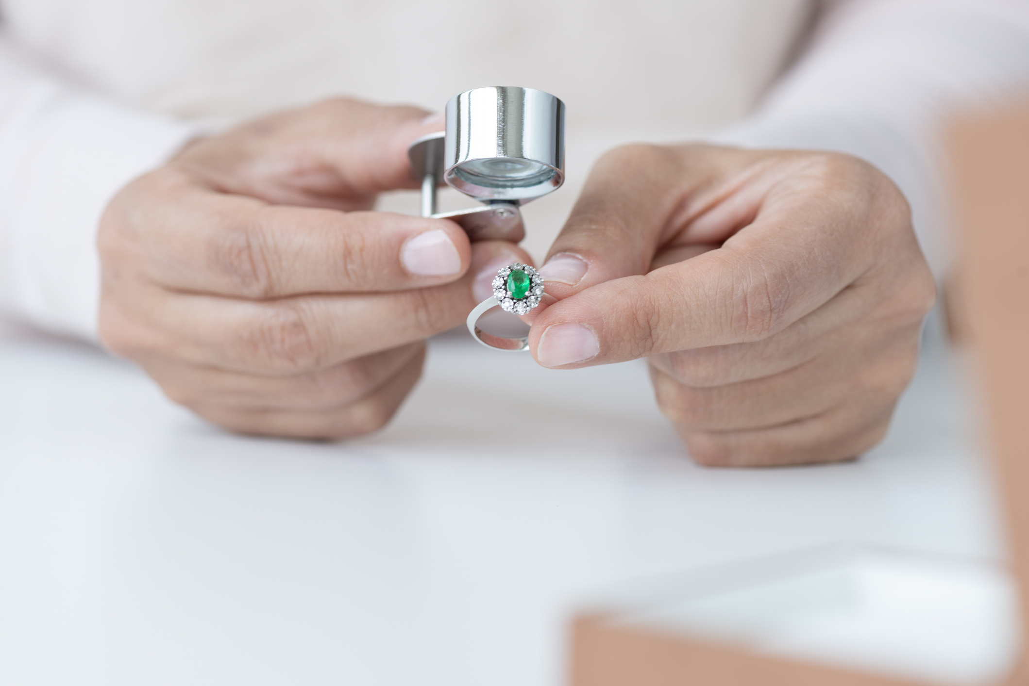 Jeweler inspecting emerald ring with loupe