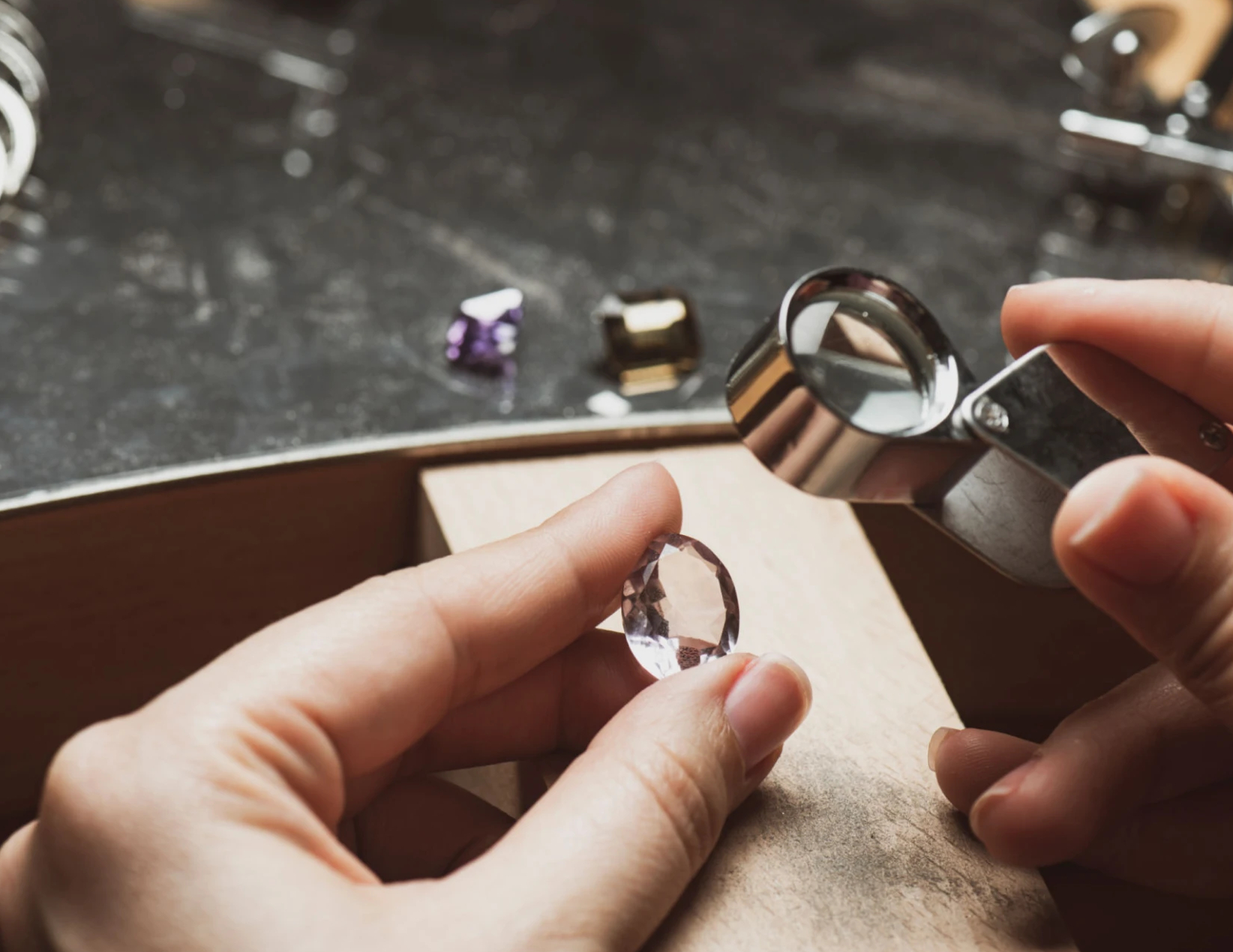 Jeweler inspecting faceted gemstone with loupe