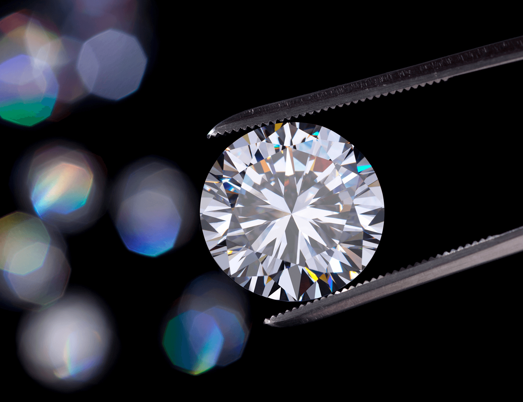 Round brilliant diamond held by tweezers