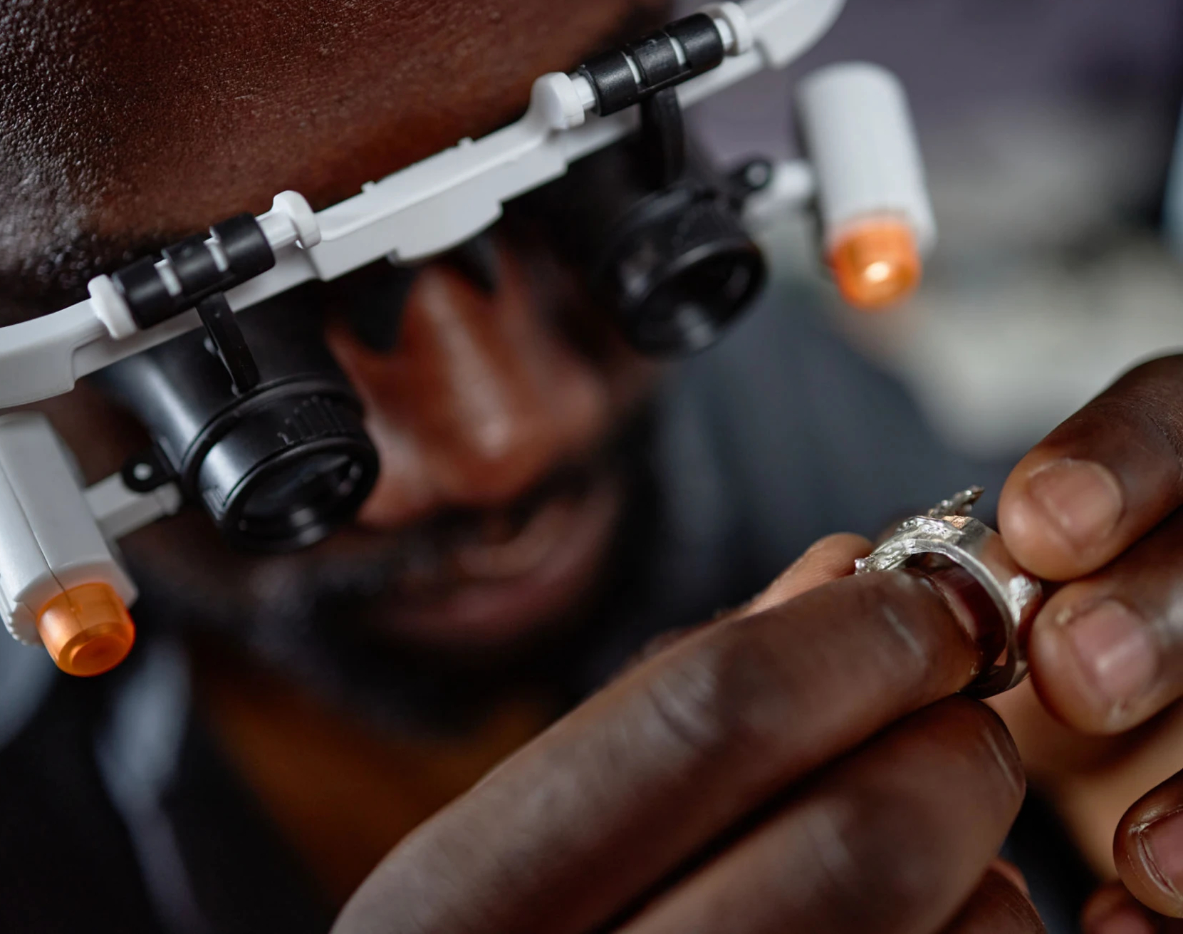 Jeweler inspecting diamond ring with magnifying loupe