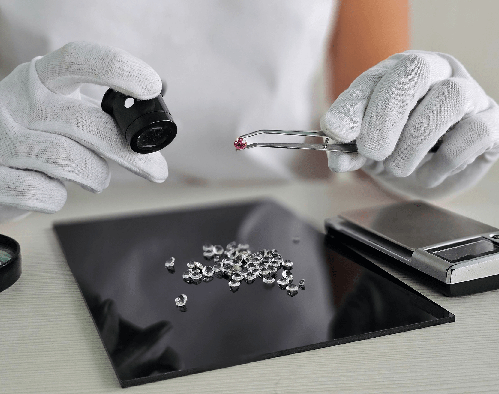 Jeweler inspecting ruby among loose diamonds
