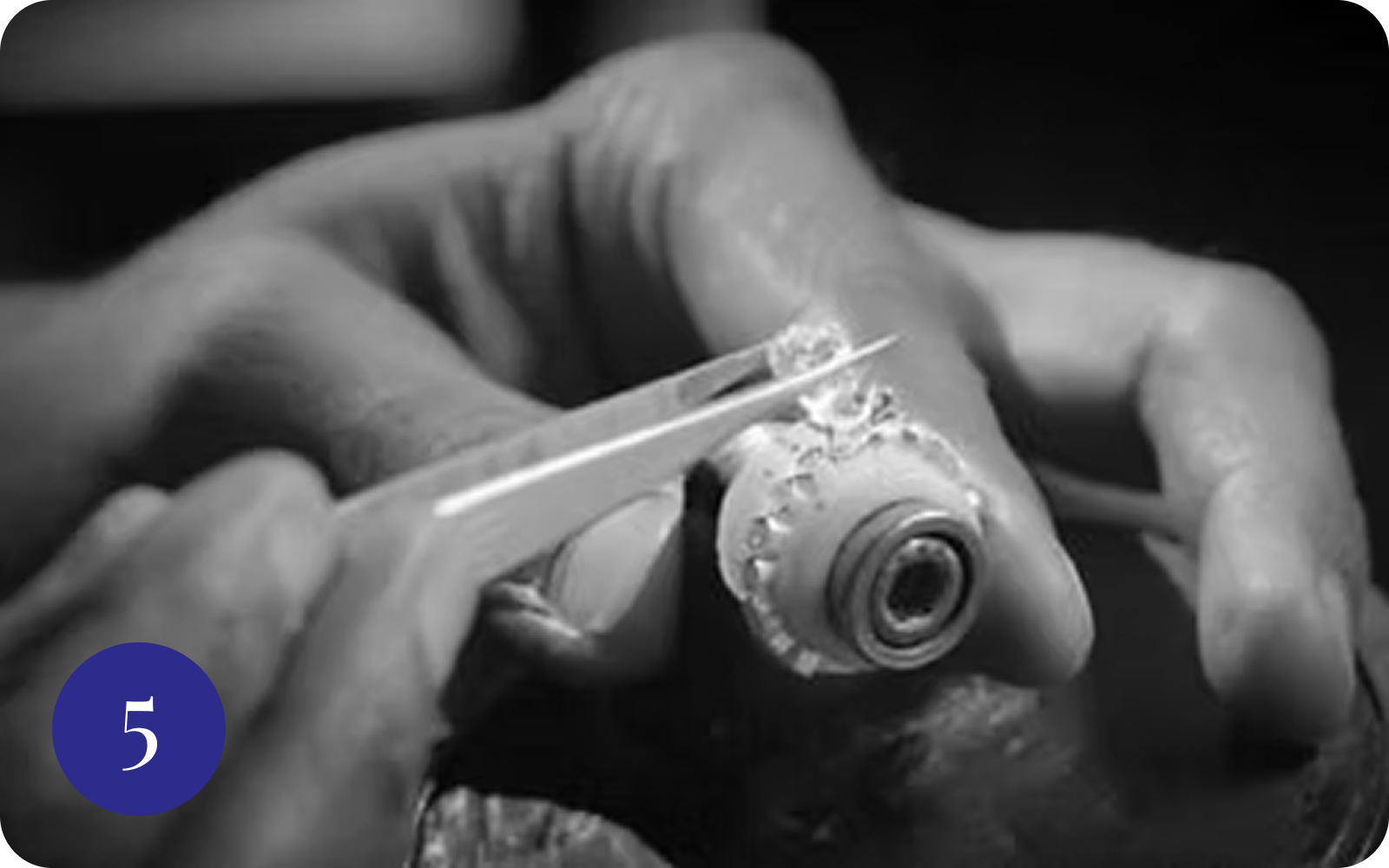 Tweezers setting gemstones on jewelry piece